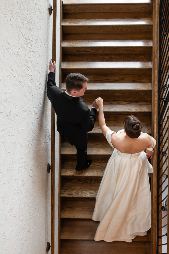 overtop view of groom escorting bride up the stairs