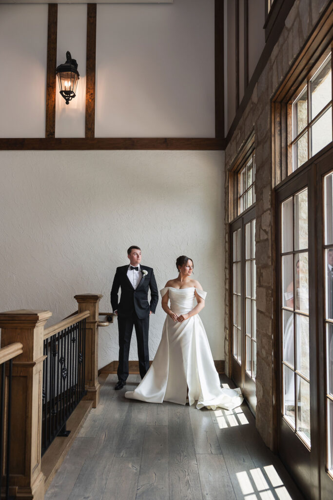 bride and groom stand in front of big windows at Silver Oaks Chateau