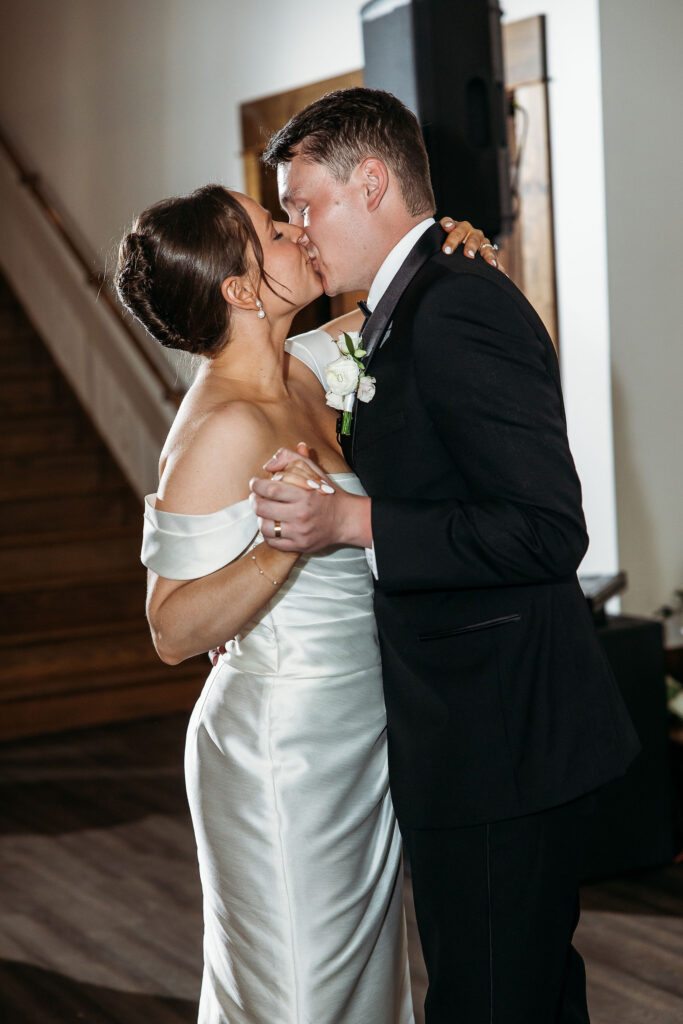 bride and groom kiss while dancing