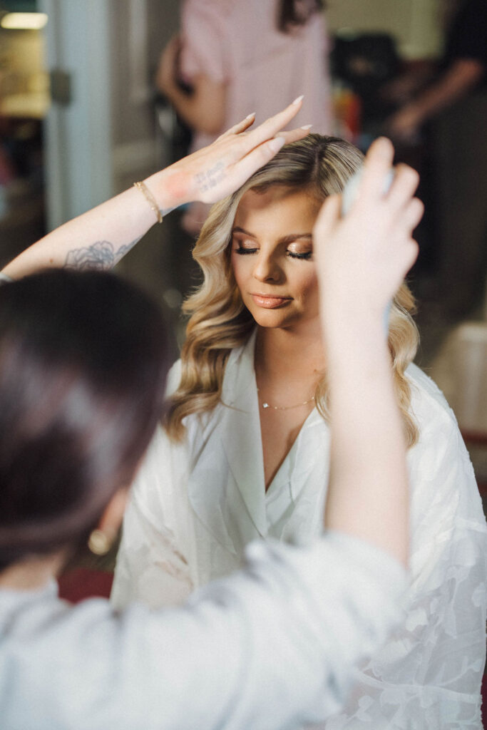 bride getting her hair done on wedding morning