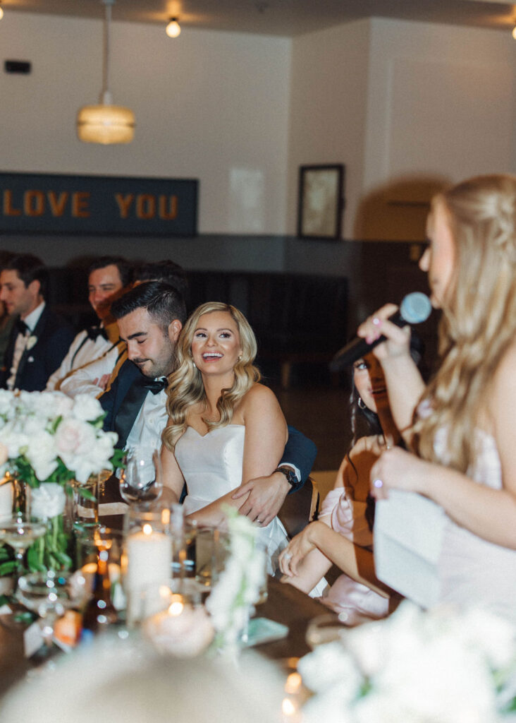 bride and groom joyfully laugh during wedding toasts