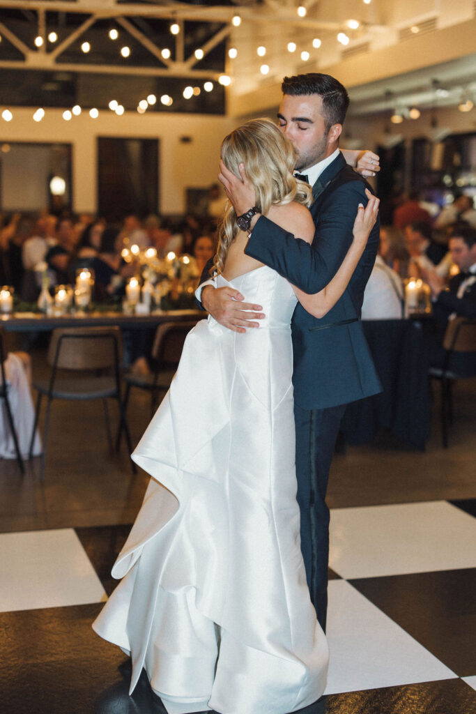 groom kisses bride white dancing