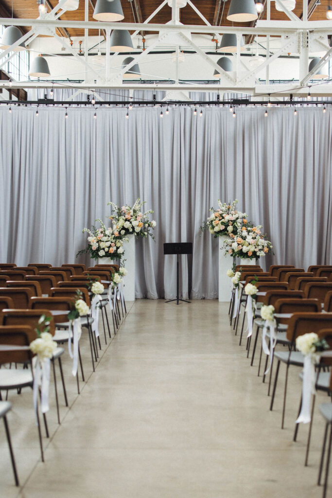 Olive and Oak indoor wedding ceremony with pipe and drape