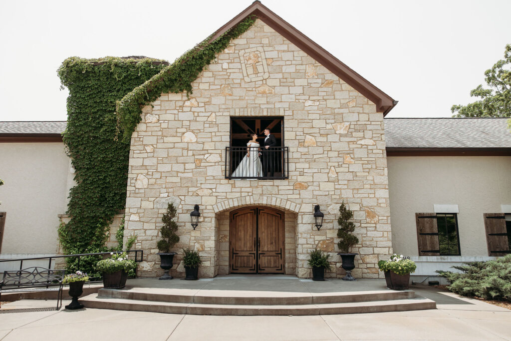 bride and groom stand on balcony at Silver Oaks Chateau wedding venue