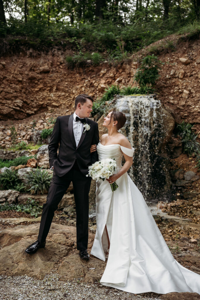 bride and groom posed outside of Silver Oaks Chateau at waterfall