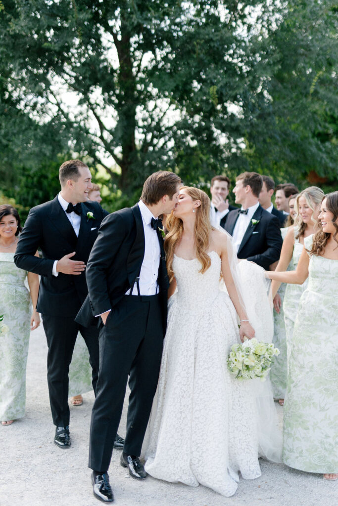 Bride and Groom kiss during wedding party pictures in Forest Park
