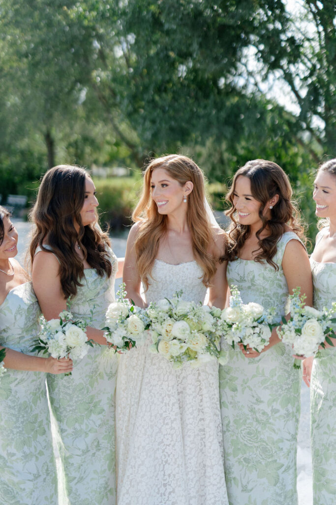 Bride and Bridesmaids smiling and holding their bouquets