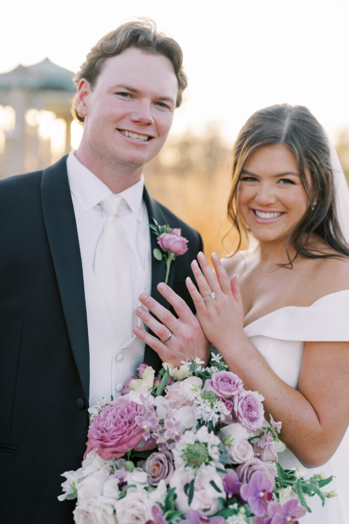 bride and groom show off their wedding rings